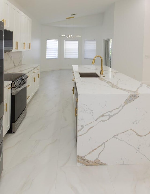 kitchen featuring marble finish floor, range with electric stovetop, white cabinetry, and a sink