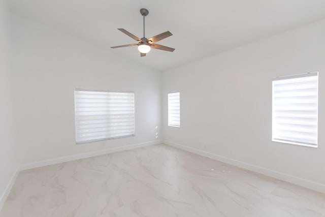 empty room featuring ceiling fan, baseboards, and vaulted ceiling