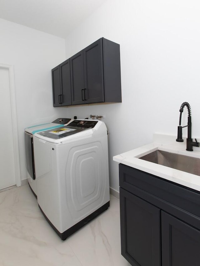 laundry area featuring cabinet space, marble finish floor, washer and clothes dryer, and a sink