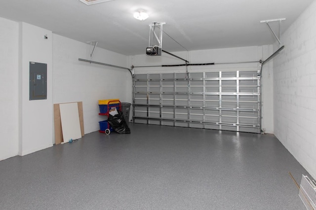 garage with concrete block wall, electric panel, a garage door opener, and visible vents