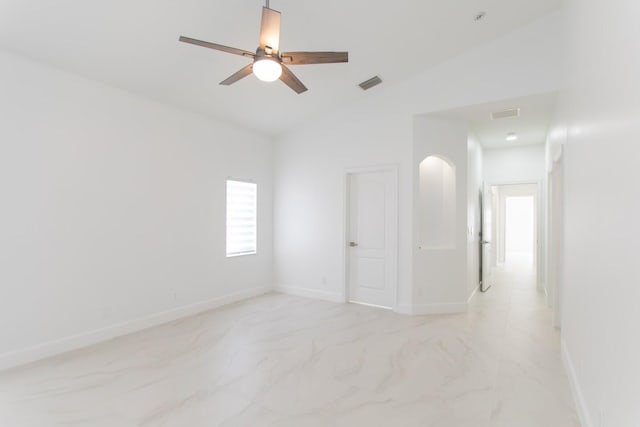 spare room featuring lofted ceiling, marble finish floor, visible vents, and baseboards