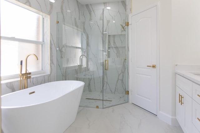 full bathroom with a freestanding bath, marble finish floor, a marble finish shower, and vanity