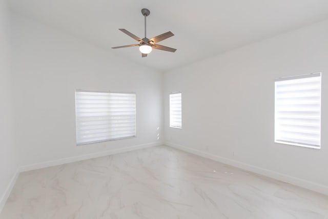 unfurnished room featuring baseboards, marble finish floor, lofted ceiling, and ceiling fan
