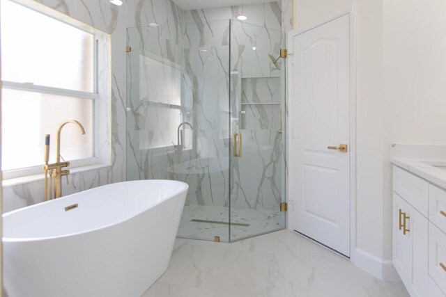 full bath featuring marble finish floor, baseboards, a soaking tub, and vanity