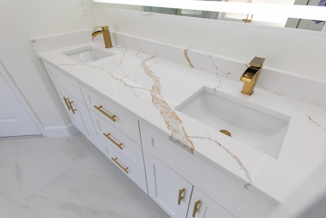 bathroom with marble finish floor and a sink