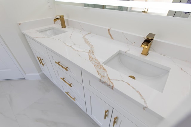 bathroom featuring marble finish floor and a sink