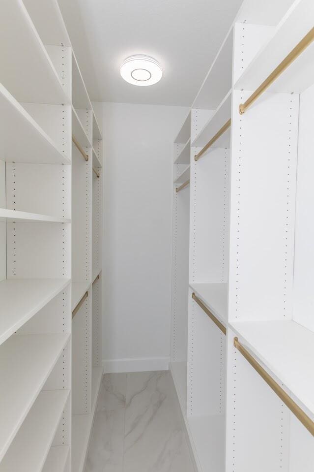 walk in closet with marble finish floor