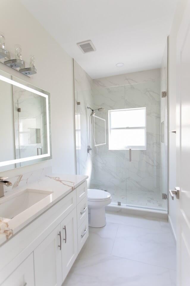 bathroom with vanity, visible vents, a marble finish shower, toilet, and marble finish floor