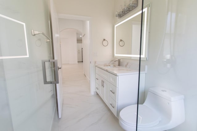 bathroom featuring toilet, marble finish floor, and vanity