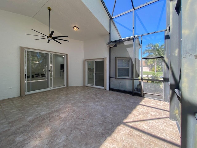 unfurnished sunroom featuring vaulted ceiling and a ceiling fan