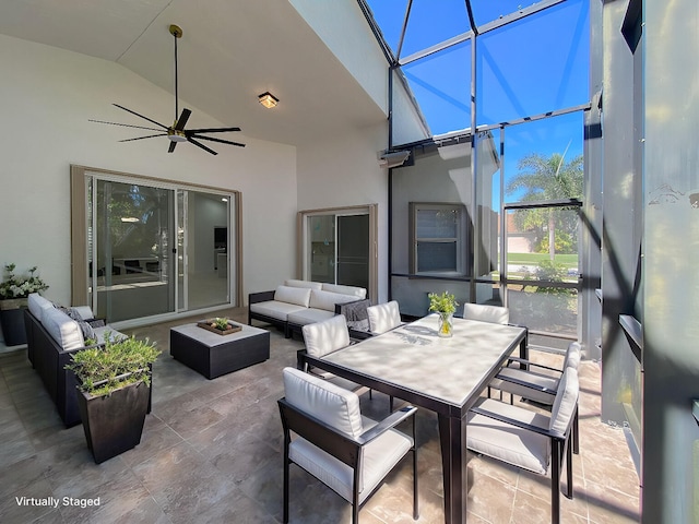 view of patio / terrace featuring outdoor dining space, glass enclosure, outdoor lounge area, and a ceiling fan