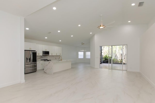 kitchen with appliances with stainless steel finishes, open floor plan, visible vents, and white cabinets