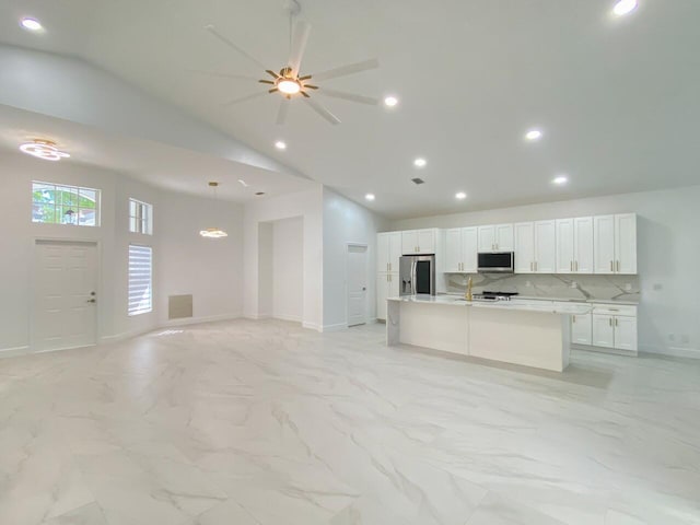 kitchen with stainless steel appliances, open floor plan, white cabinetry, and marble finish floor