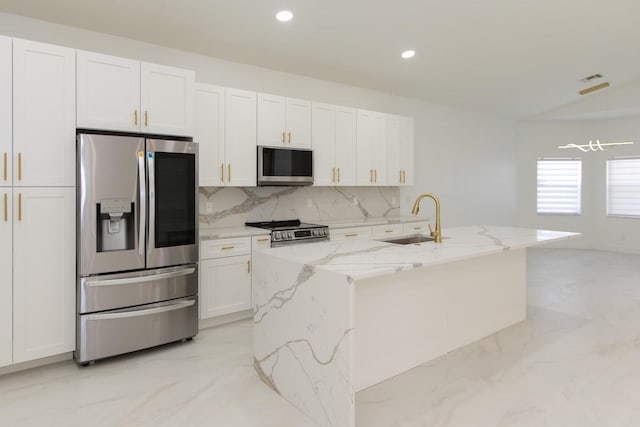 kitchen featuring light stone counters, white cabinets, marble finish floor, stainless steel appliances, and a sink