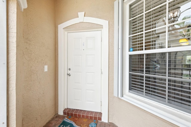 entrance to property featuring stucco siding