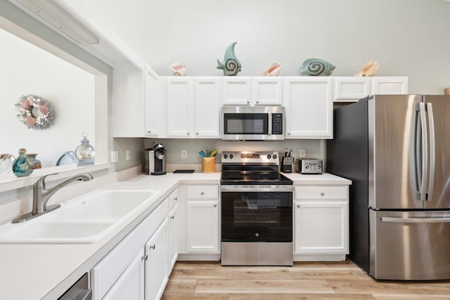 kitchen with white cabinets, stainless steel appliances, and a sink