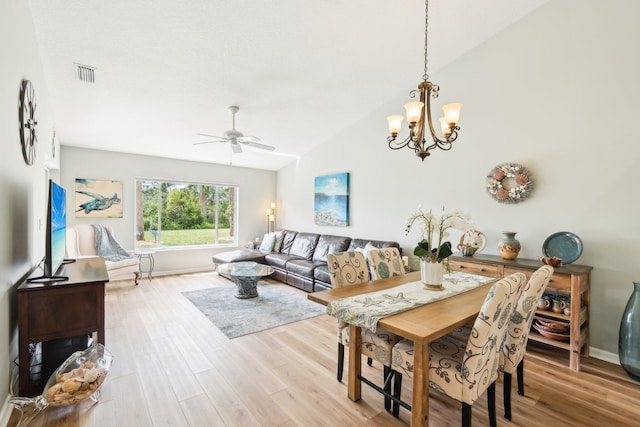 dining room with visible vents, vaulted ceiling, light wood-type flooring, baseboards, and ceiling fan with notable chandelier