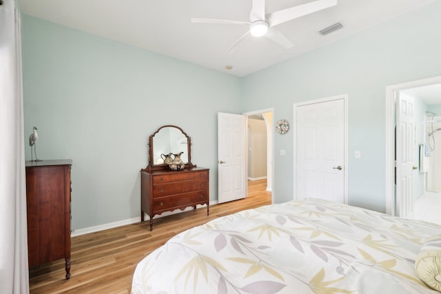 bedroom featuring light wood-style floors, baseboards, visible vents, and a ceiling fan