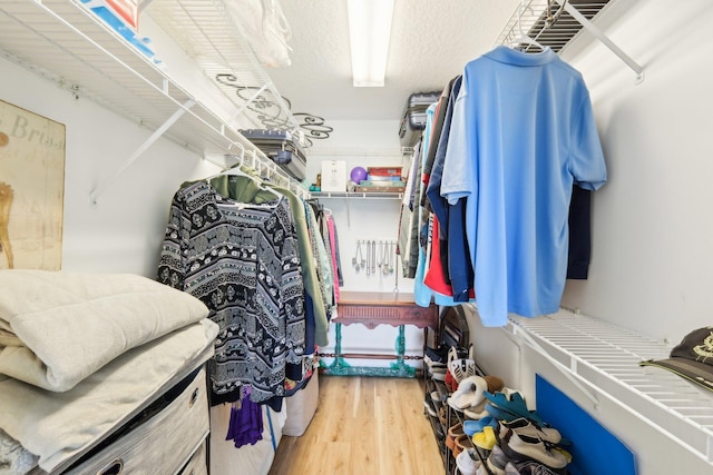 walk in closet with wood finished floors