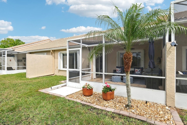 back of property featuring a lanai, a yard, a tiled roof, and stucco siding