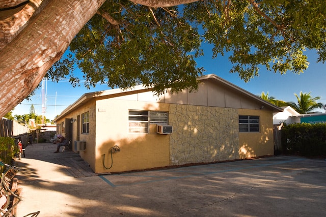 view of side of home featuring fence and cooling unit