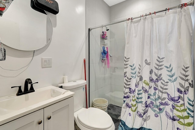 bathroom featuring toilet, a shower stall, and vanity