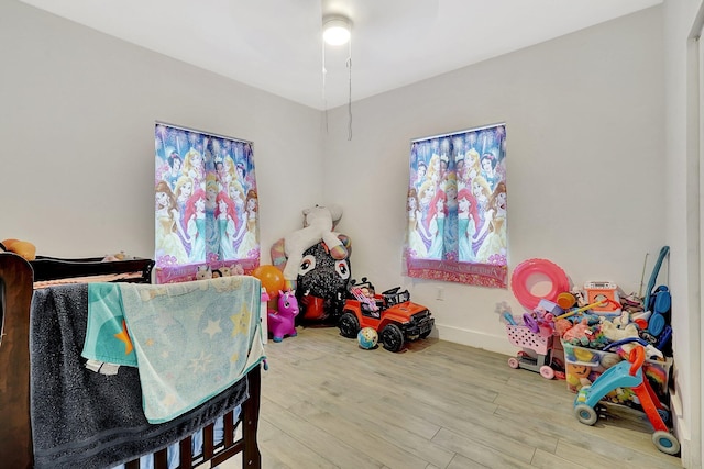 rec room with baseboards and wood finished floors