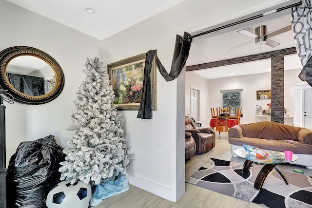 living area with ceiling fan, light wood-style flooring, and baseboards