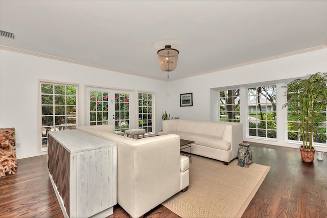living room featuring baseboards, visible vents, ornamental molding, and dark wood finished floors