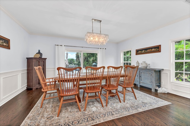dining space featuring a wainscoted wall, a wealth of natural light, a chandelier, and crown molding