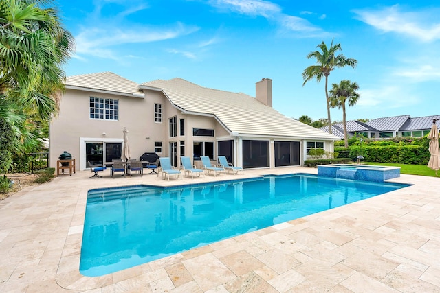 view of pool with a patio area, a sunroom, and a pool with connected hot tub