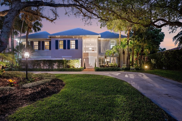 view of front of home with a front yard, driveway, and stucco siding