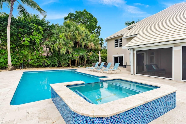 view of swimming pool with a patio area and a pool with connected hot tub