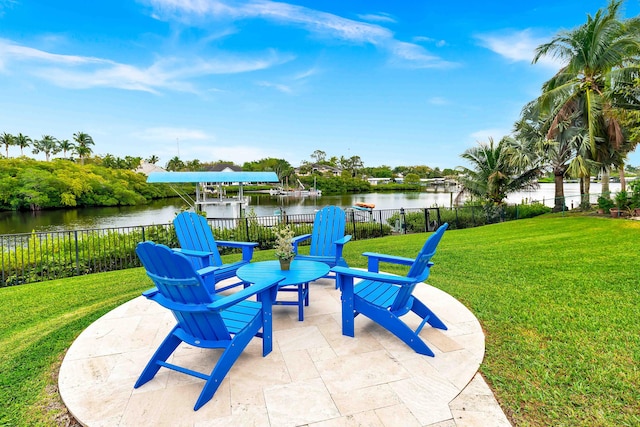 view of patio featuring fence and a water view
