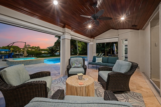 patio terrace at dusk with an outdoor living space, a ceiling fan, and a pool with connected hot tub