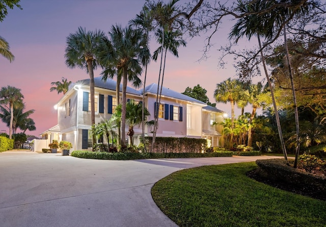 view of front of house with stucco siding and curved driveway