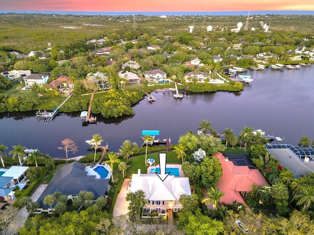 aerial view at dusk with a residential view and a water view
