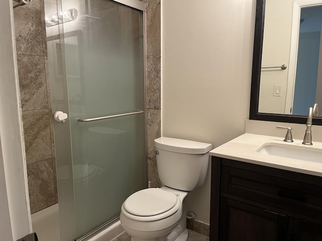 full bathroom with vanity, a shower stall, and toilet