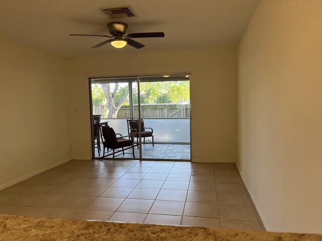 unfurnished room with light tile patterned floors, baseboards, visible vents, and a ceiling fan