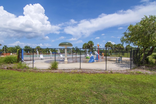 community jungle gym with fence and a yard