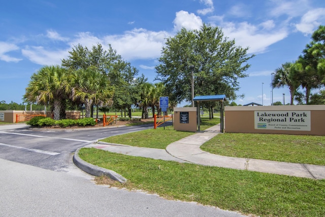 view of community featuring uncovered parking and a lawn