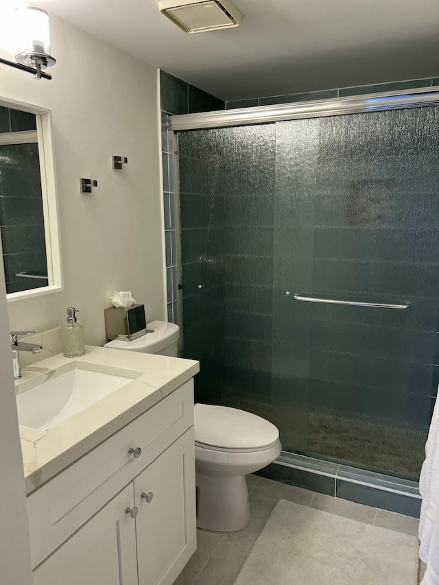 full bathroom with tile patterned flooring, a shower stall, toilet, and vanity