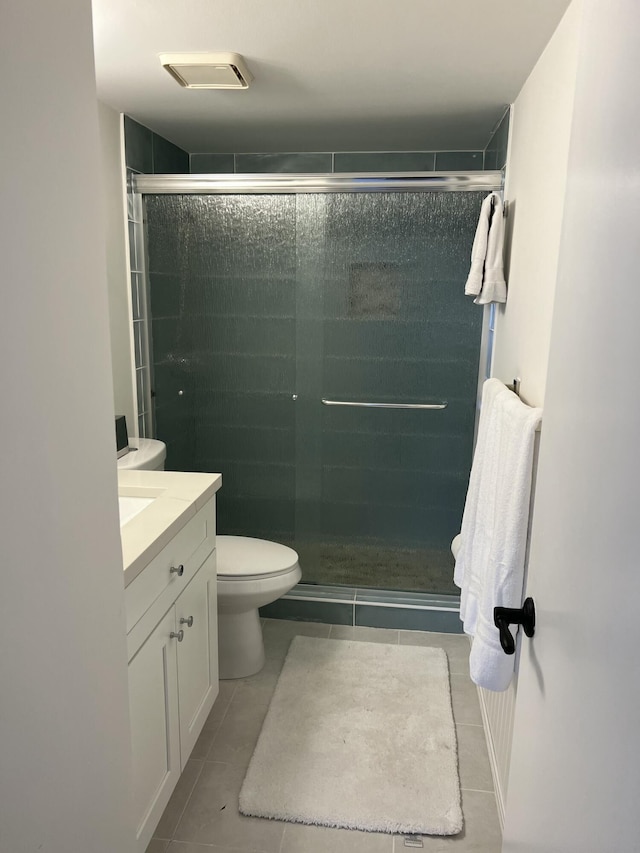 bathroom with a stall shower, tile patterned flooring, vanity, and toilet