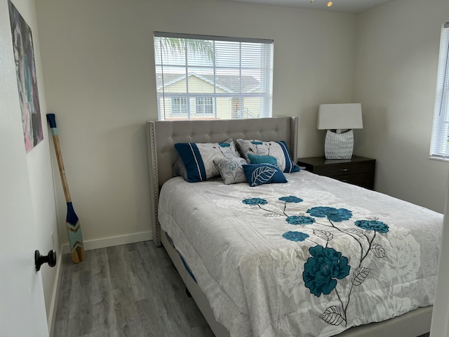 bedroom featuring wood finished floors and baseboards