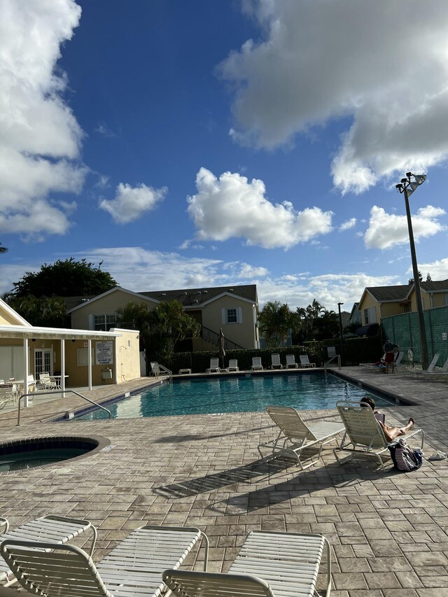 pool with a patio area and fence