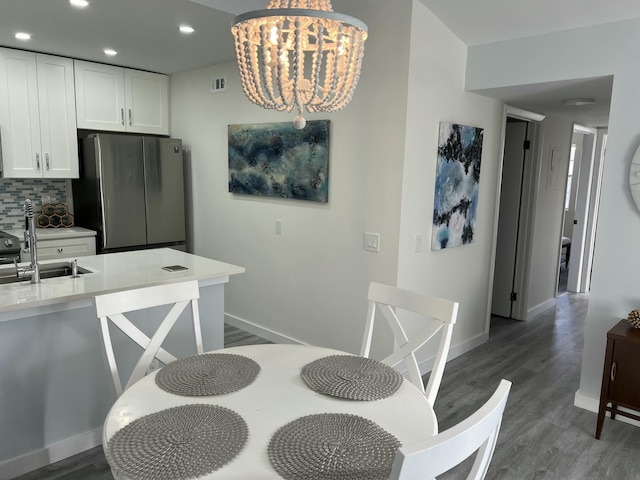 dining space featuring baseboards, a chandelier, wood finished floors, and recessed lighting