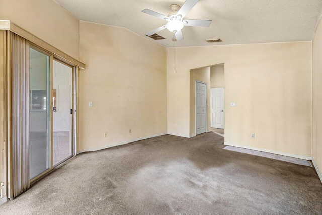 carpeted empty room with lofted ceiling, ceiling fan, visible vents, and baseboards