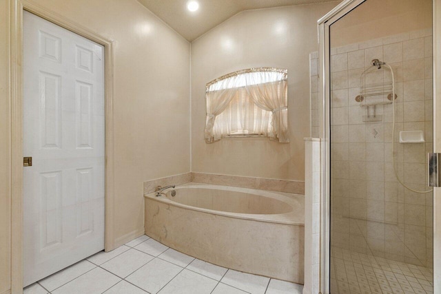 bathroom featuring a stall shower, a garden tub, lofted ceiling, and tile patterned floors