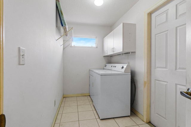 washroom with washer / dryer, cabinet space, baseboards, and light tile patterned floors