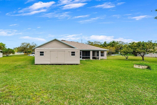 back of property featuring a sunroom and a lawn